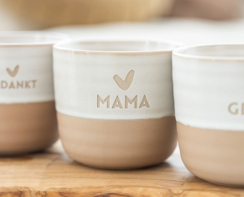 Theemok-aardewerk-Mama Theemok met mama erop en daarboven een hartje. De bovenkant van de theemok is wit en de onderkant steenoranje.